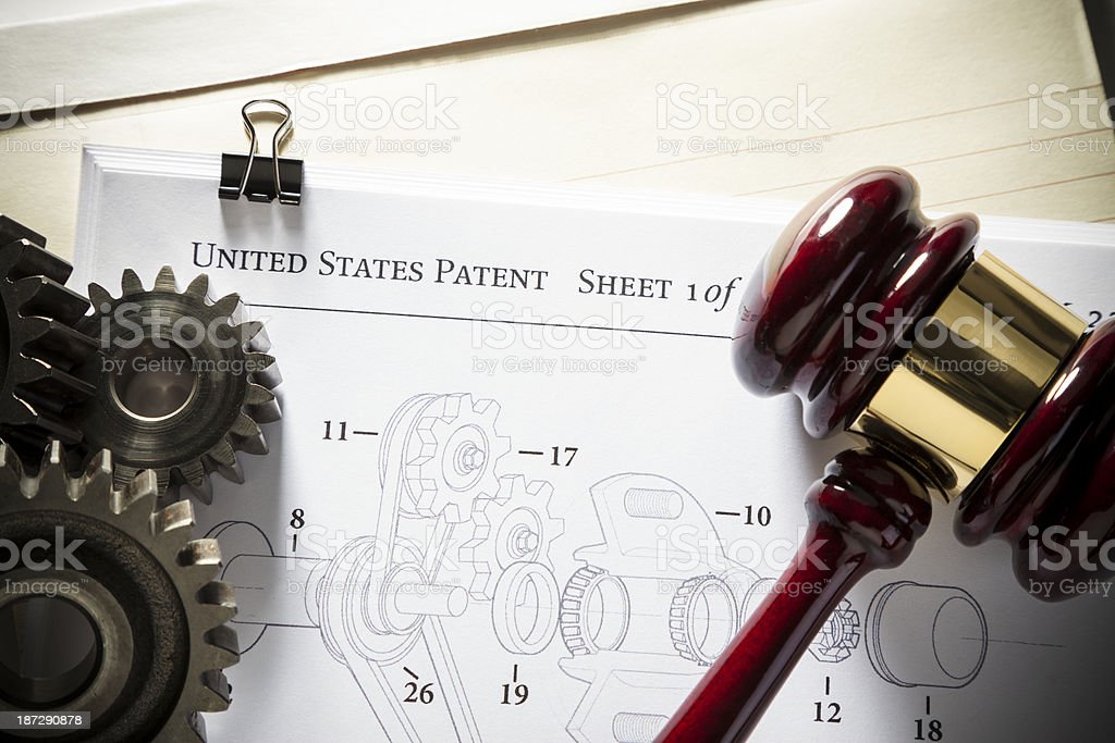 Gavel next to gears and mechanical diagram for patent application. Concept for patent attorney. IP litigation